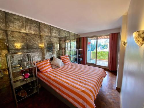 - une chambre avec un lit avec des draps rayés et une fenêtre dans l'établissement NICE 2P Panoramic Sea View Wi-Fi AC, à Nice