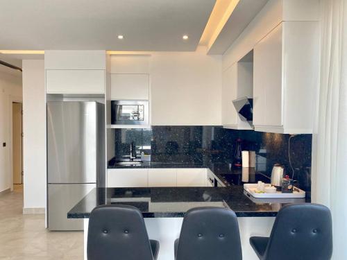 a kitchen with white cabinets and black counter tops at Boutique 16 - Alanya Experience in Alanya