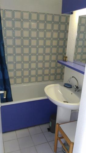 une salle de bain avec un lavabo et une baignoire dans l'établissement Beau appartement face à l eau, au Barcarès