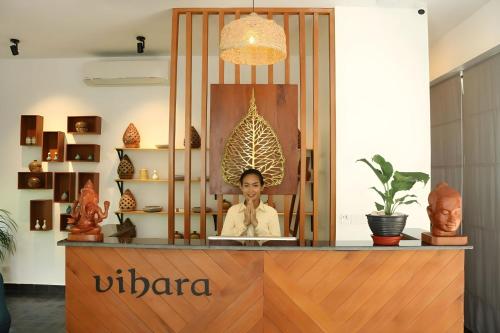 a woman is sitting at a counter in a store at Vihara The City of Temples in Siem Reap