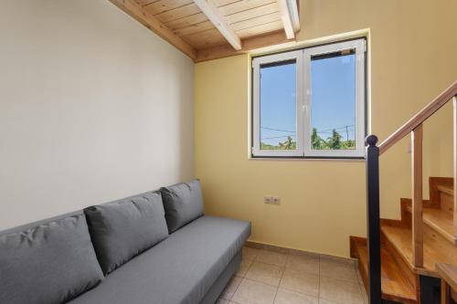 a living room with a couch and a window at Villa Rea Chania in Argoulidhés