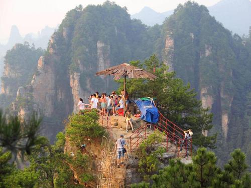 a group of people standing on the edge of a mountain at Zhangjiajie Tianmenshan Xuyuan Hotel in Zhangjiajie