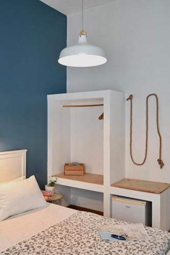 a bedroom with a bed with a white headboard at Matinee Rooms in Mattinata