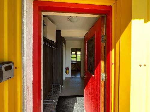 a hallway with colorful walls and a red door at Lækjarhus Farm Holidays in Borgarhöfn