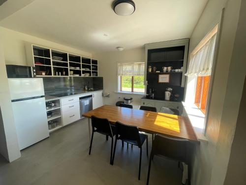 a kitchen with a wooden table and black cabinets at Lækjarhus Farm Holidays in Borgarhöfn