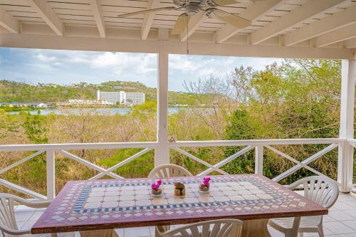 a table and chairs on a porch with a view at Loft Apartment Ocean View in Saint Johnʼs