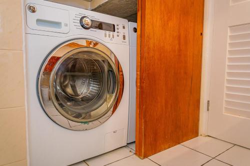 a white washing machine sitting in a room at Loft Apartment Ocean View in Saint Johnʼs
