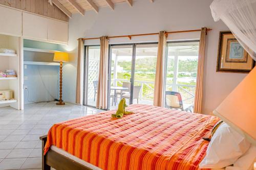 a bedroom with a bed with an orange blanket at Loft Apartment Ocean View in Saint Johnʼs