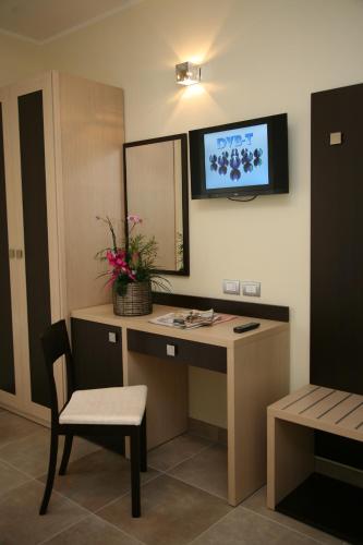 Habitación con escritorio y TV en la pared. en Albergo Borgonovo, en Badia