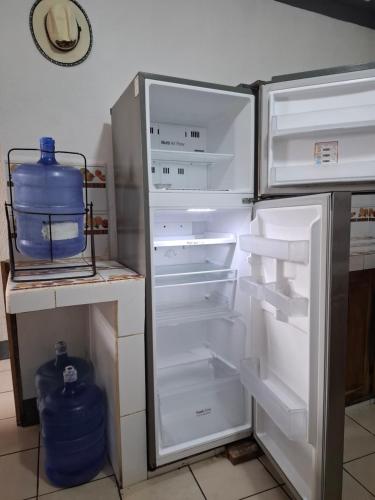 a refrigerator with its door open with a gallon of water in it at The New Shelter in Panajachel