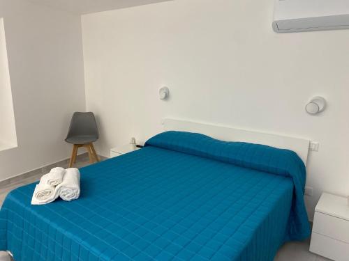 a bedroom with a blue bed with shoes on it at Gioia Barocca in Scicli
