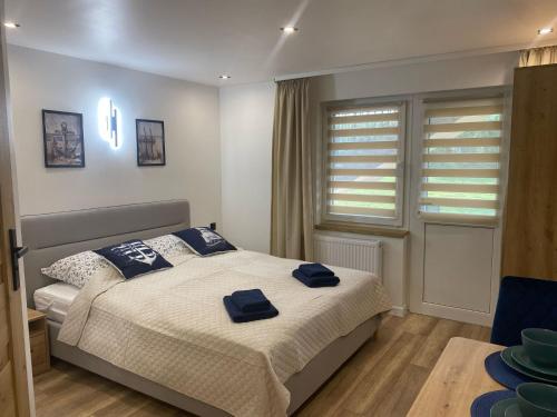Un dormitorio con una cama con toallas azules. en AGWA - Pokój typu Studio, en Władysławowo