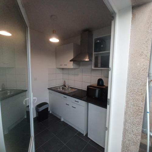 une petite cuisine avec un évier et un comptoir dans l'établissement Studio cosy 10 min des plages, à Saint-Brieuc