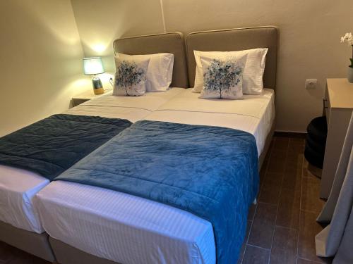 a large bed with blue and white sheets and pillows at Sami Loft in Sami