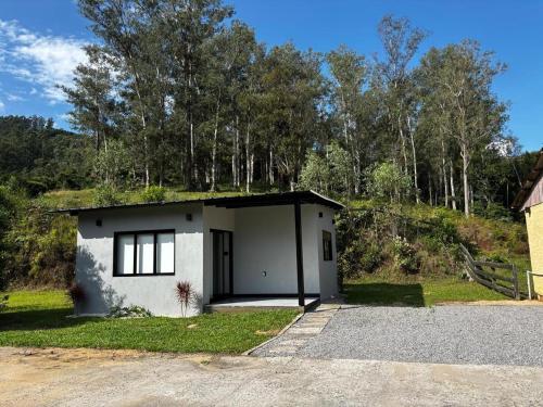 a small white building with a grass roof at Casa do Bem Estar Picada Café in Picada Cafe