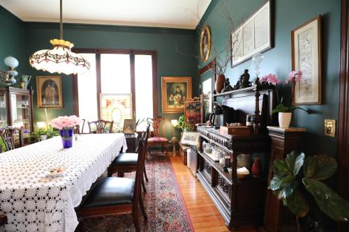 a dining room with a table and a room with green walls at Adams Pragge House - Victorian Bed & Breakfast in Port Townsend