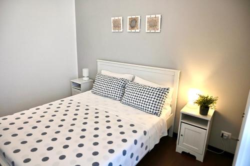 a bedroom with a white bed and two night stands at Matinee Rooms in Mattinata