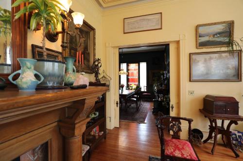 a living room with a fireplace with vases on it at Adams Pragge House - Victorian Bed & Breakfast in Port Townsend