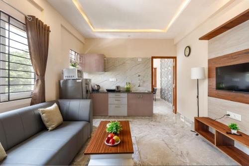 una sala de estar con un sofá y una mesa en Move-Inn OBS Serviced Apartments Koramangala, en Bangalore