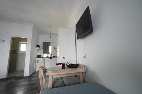 a room with a table and a tv on a wall at On Sight Studio l in Myrties