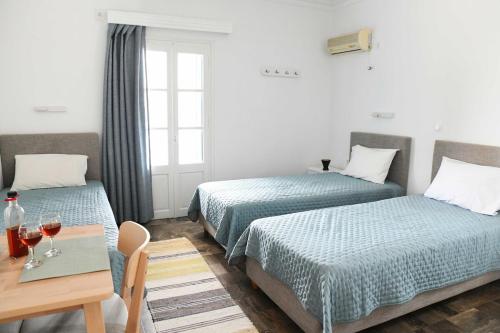 a hotel room with two beds and a table with wine glasses at On Sight Studio l in Myrties