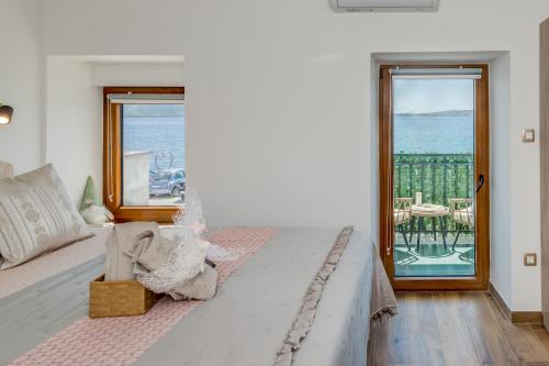 a bedroom with a bed with a view of the ocean at Seafront Apartment Balcony Panoramic View in Kaštela