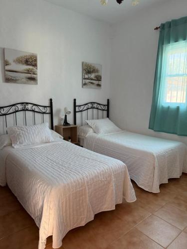 a bedroom with two beds and a window at casa lucia in Cádiz