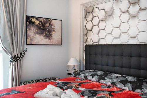 a bedroom with a bed with a red comforter at Antico Borgo Monregale in Mondovì