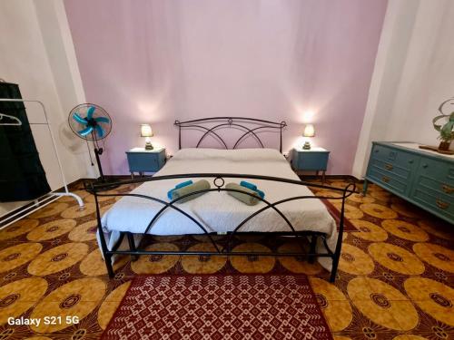 a bedroom with a bed with two lamps and a rug at House Le Gallinelle in Assemini