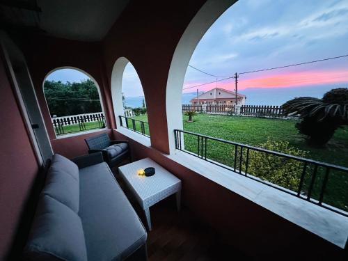 a living room with a couch and two windows at Nikos Apartments Corfu in Agios Stefanos