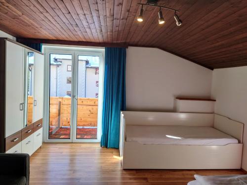 クライナルにあるHaus Daniel Schartnerのベッドとガラスの引き戸のある寝室