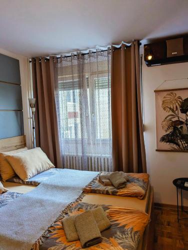 two beds in a room with a window at Studio Sunset in Voždovac