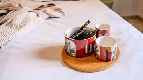 two cups on a wooden tray on a bed at Casa Nova Maison d'hôtes in Sagone