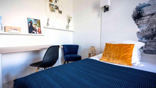 a bedroom with a bed and two blue chairs at Casa Nova Maison d'hôtes in Sagone