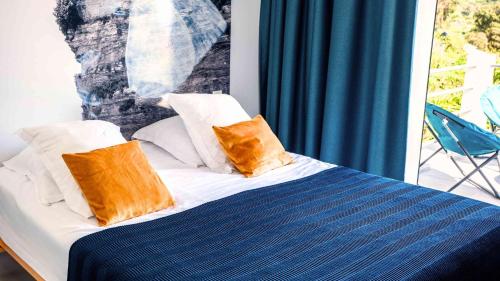 a bed with two pillows on top of it at Casa Nova Maison d'hôtes in Sagone