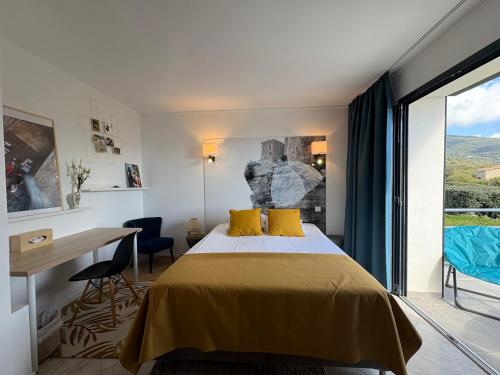 a bedroom with a bed and a desk and a window at Casa Nova Maison d'hôtes in Sagone