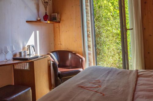 a room with a chair and a desk and a window at VALDONICA WINERY Fine Dine & Wine Hotel in Sassofortino