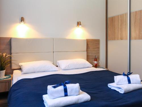 a bedroom with a large bed with towels on it at Apartamenty Marina Jastrzębia Góra in Jastrzębia Góra