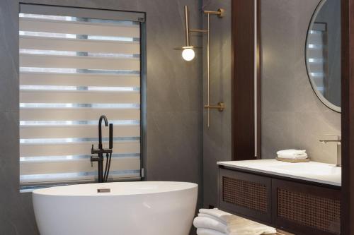 a bathroom with a tub and a sink at Zhangjiajie Tianmenshan Xuyuan Hotel in Zhangjiajie