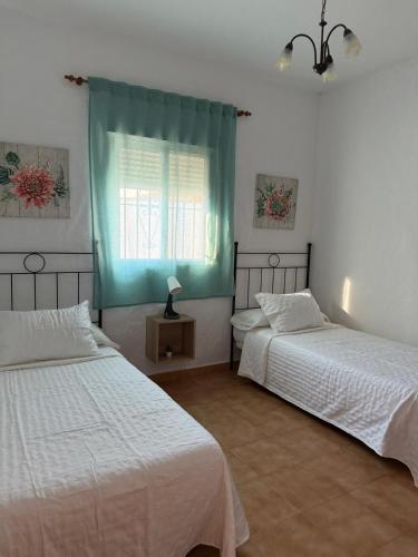 a bedroom with two beds and a window at casa lucia in Cádiz