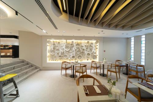 a restaurant with tables and chairs and a large window at Hill Top Hotel in Aqaba
