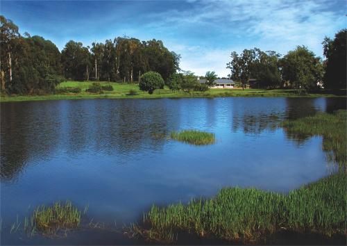 a large lake with grass in the middle of it at Fordoun Hotel and Spa in Nottingham Road
