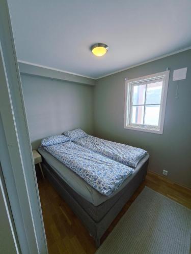 a bedroom with a bed and a window at Tjeldsund Tide nr. 5 in Steinsland