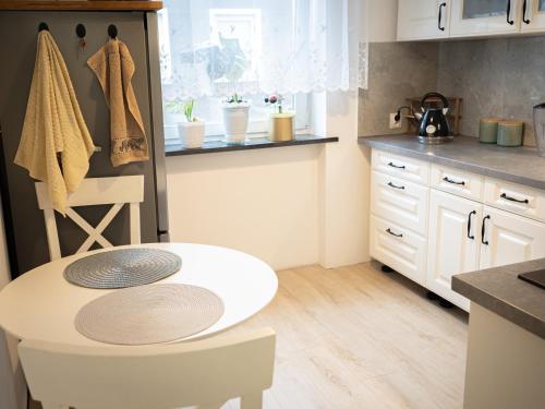 a kitchen with a white table in a kitchen at Apartament Vikicentrum in Bolesławiec