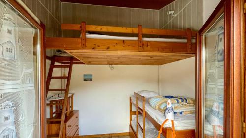 un lit superposé dans une petite pièce avec une échelle dans l'établissement Duplex house B34 Les Villas de La Palmyre, aux Mathes