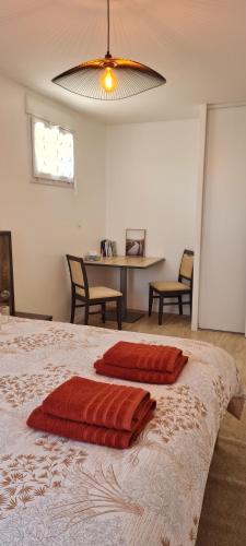 une chambre avec un lit avec deux oreillers rouges dessus dans l'établissement Appart Sud III Rouen Nataya, à Rouen