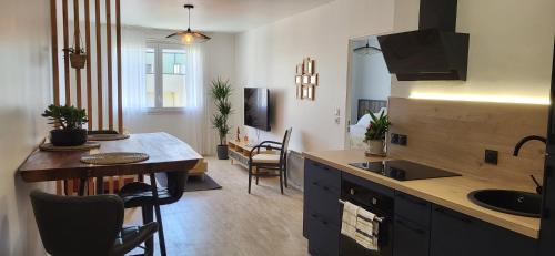 - une cuisine avec un évier et une table dans une chambre dans l'établissement Appart Sud III Rouen Nataya, à Rouen