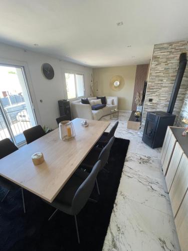 un salon avec une table et des chaises en bois dans l'établissement Maison 24 h du Mans, à Spay