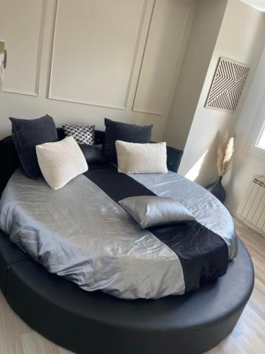 - un grand lit avec des oreillers dans l'établissement Maison 24 h du Mans, à Spay