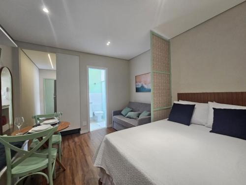 a bedroom with a bed and a table and a couch at Studio on the best beach in Santos with parking included in Santos